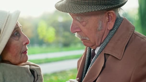 Ernstige bejaarde echtpaar staande in een park — Stockvideo