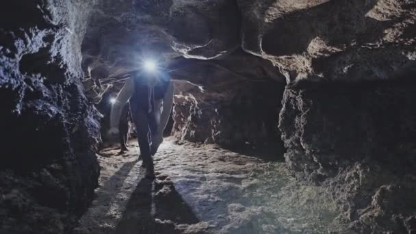 Group of cavers hiking through cave — Stock Video