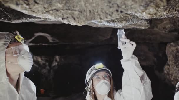 Grupo de mujeres científicas probando en una cueva de roca — Vídeo de stock