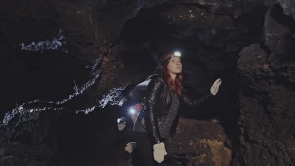 Groupe de spéléologues marchant dans une grotte rocheuse — Video