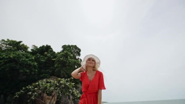 Glückliche blonde Frau in rotem Kleid und Sonnenhut - Zeitlupe. — Stockvideo