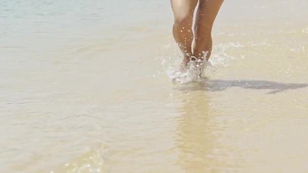 Γυναίκα με καλλίγραμμα πόδια που τρέχουν μέσα από τη θάλασσα - αργή κίνηση — Αρχείο Βίντεο