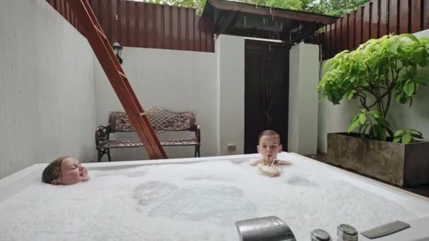 两个孩子在户外按摩浴缸 — 图库视频影像