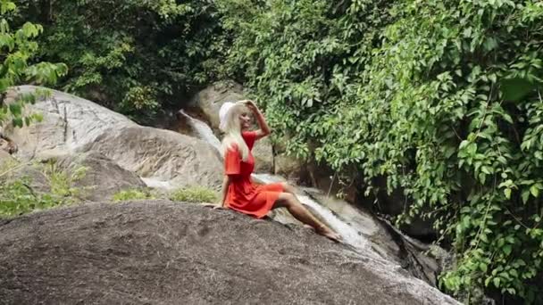 Frau in Kleid und Hut gegen tropischen Wasserfall - Zeitlupe. — Stockvideo