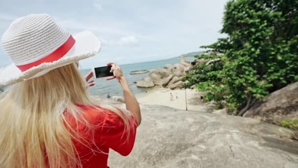 Mujer tomando fotos de la orilla del mar — Vídeo de stock