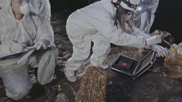 Investigating and collecting analyzes of strange unsafe stones in the old caves underground — Stock Video