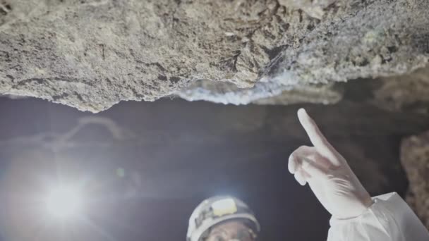 Los científicos observan como el agua en cuevas subterráneas se filtra a través de grietas en piedras. Investigación de fenómenos naturales catastróficos . — Vídeos de Stock