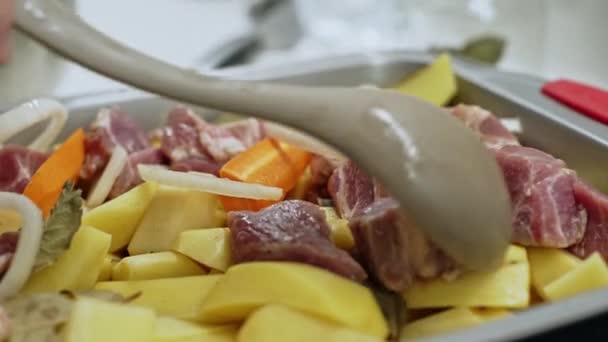Raw ingredients - meat, carrots, potatoes for cooking and dish of baked potatoes with pork meat — Stock Video