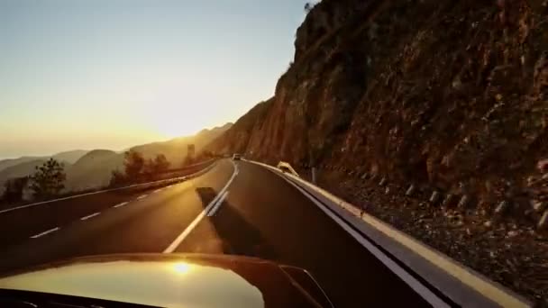 Camino de montaña contra la puesta de sol desde el aspecto del coche - POV wiev . — Vídeo de stock