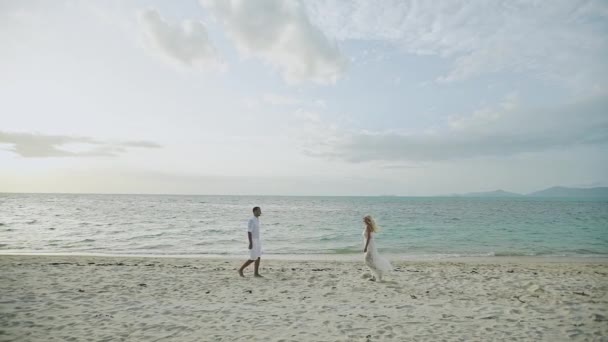 Šťastný pár spuštěný na tropické pláži při západu slunce, dovolená-pomalý pohyb — Stock video