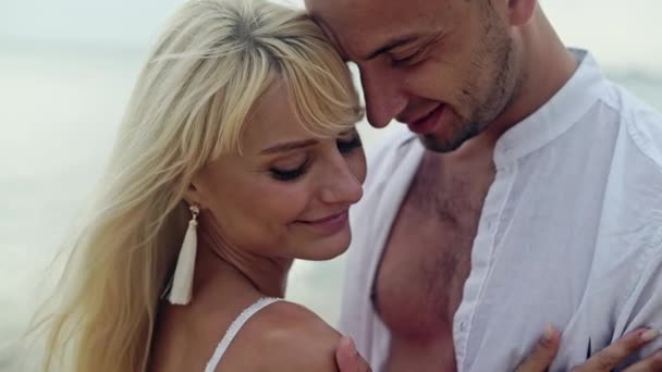 Boldog pár játszik, és fut a tengerparton naplementekor — Stock videók