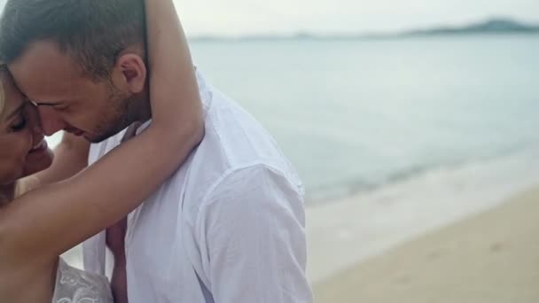 Jovem casal apaixonado andando no mar de mãos dadas olhando no pôr do sol, conceito de Dia dos Namorados — Vídeo de Stock
