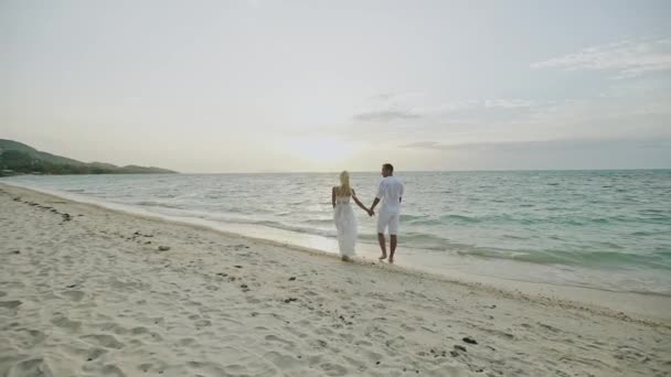 Huwelijksreis aan zee. Achteraanzicht van liefdevolle paar lopen weg bij Sandy Beach-Slow Motion. — Stockvideo