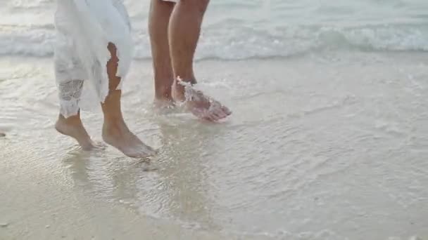 Pariskunta rakastuneena auringonnousun rannalla. Lähellä jalat - slwo motion . — kuvapankkivideo