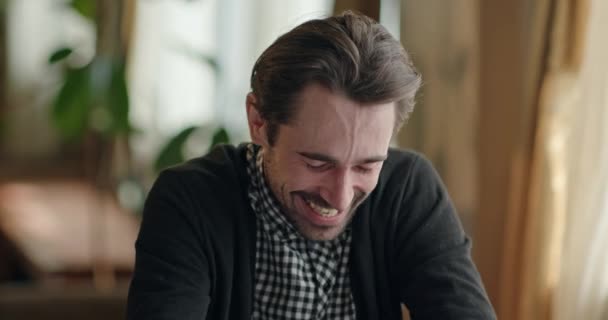 Hombre riendo mientras recuerda recuerdos divertidos — Vídeos de Stock
