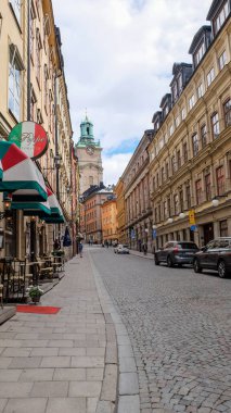 Gamlan Stan caddeleri. Gamla Stan 'in hareketli küçük adası Stockholm' ün Eski Kasabası. Kaldırım döşeli caddeler ve 17. ve 18. caddelerden kalma renkli binalar. 