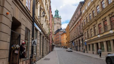 Gamlan Stan caddeleri. Gamla Stan 'in hareketli küçük adası Stockholm' ün Eski Kasabası. Kaldırım döşeli caddeler ve 17. ve 18. caddelerden kalma renkli binalar. 