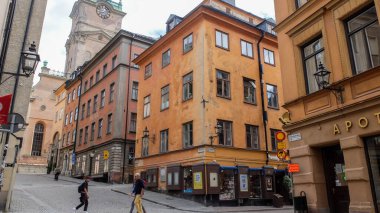 Gamlan Stan caddeleri. Gamla Stan 'in hareketli küçük adası Stockholm' ün Eski Kasabası. Kaldırım döşeli caddeler ve 17. ve 18. caddelerden kalma renkli binalar. 