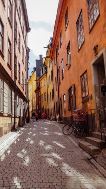 Gamlan Stan caddeleri. Gamla Stan 'in hareketli küçük adası Stockholm' ün Eski Kasabası. Kaldırım döşeli caddeler ve 17. ve 18. caddelerden kalma renkli binalar. 