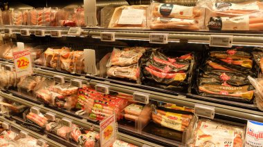 İsveç süpermarketindeki buzdolabında et: tavuk, sosis, sığır eti, salam. 