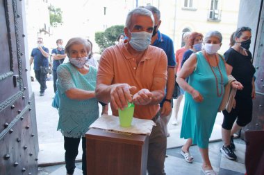 Minori, Sa, İtalya - 13 Temmuz 2020: Kiliseye girmeden önce inananlar, halka açık yerlerde covid-19 enfeksiyonunu önlemek için ellerine bir dezenfekte sıvısı verdiler.