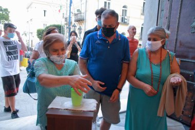 Minori, Sa, İtalya - 13 Temmuz 2020: Kiliseye girmeden önce inananlar, halka açık yerlerde covid-19 enfeksiyonunu önlemek için ellerine bir dezenfekte sıvısı verdiler.