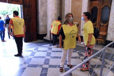 Pagani, Salerno, İtalya - 1 Ağustos 2020: Gönüllüler, Bazilika 'nın girişinde inananları karşılıyor ve ellerin akış ve sterilizasyonunu kontrol ediyorlar.