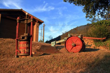 Citt della Pieve, Perugia, İtalya - 27 Ağustos 2020: Umbria 'nın kırsal kesimindeki bir evde alet dükkanı olarak kullanıldı. Dışarıda şarap üretmek için bir torna ve toprağı işlemek için bir saban görebilirsiniz..