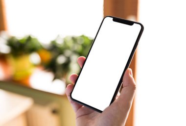 Boş ekran ve modern çerçeve ile siyah smartphone eve iç arka plan üzerinde izole daha az tasarım - tutan adam el