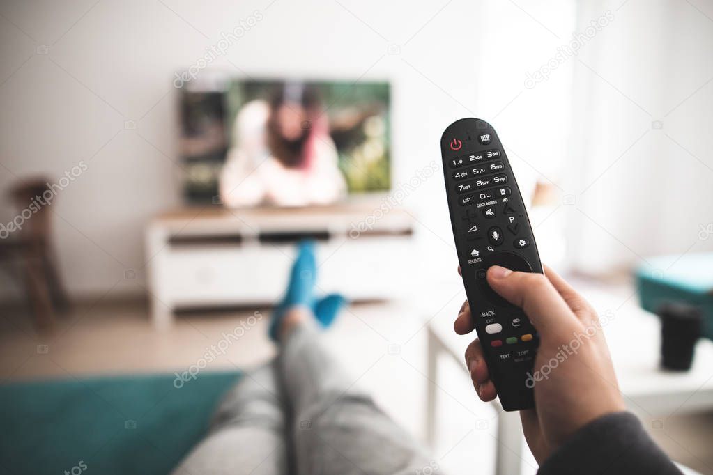 Man watching smart tv blank screen controlled by smart remote - point of view perspective