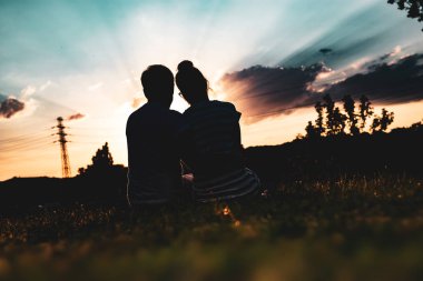 Çift karşı güzel günbatımı güneş ışınları ile sarılma