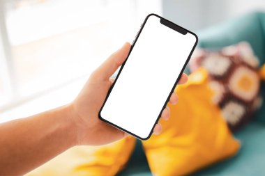 Büyük boş ekran ve modern çerçeve ile siyah smartphone daha az tasarım ev iç, oturma odasında beyaz arka plan açılı konumuna izole - tutan adam el