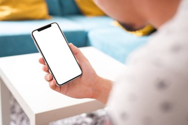 Büyük boş ekran ve modern çerçeve ile siyah smartphone daha az tasarım ev iç, oturma odasında beyaz arka plan açılı konumuna izole - tutan adam el
