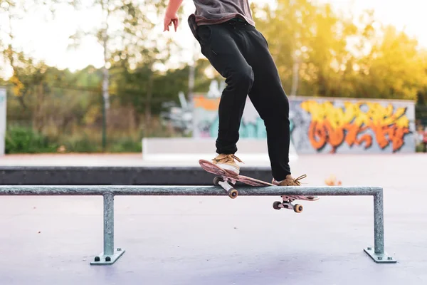 Deskorolkarz Robi Krzywy Trik Szlifowania Ławce Skateparku — Zdjęcie stockowe