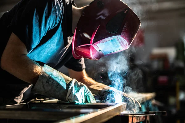 火花と煙の工場労働者の多く鋼管を溶接 — ストック写真