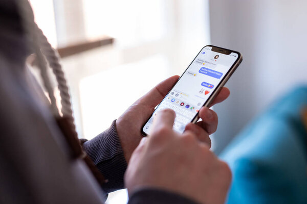 CRACOW, POLAND - NOVEMBER 15, 2018: boyfriend chatting via imessage with his girlfriend on new iPhonie Xs