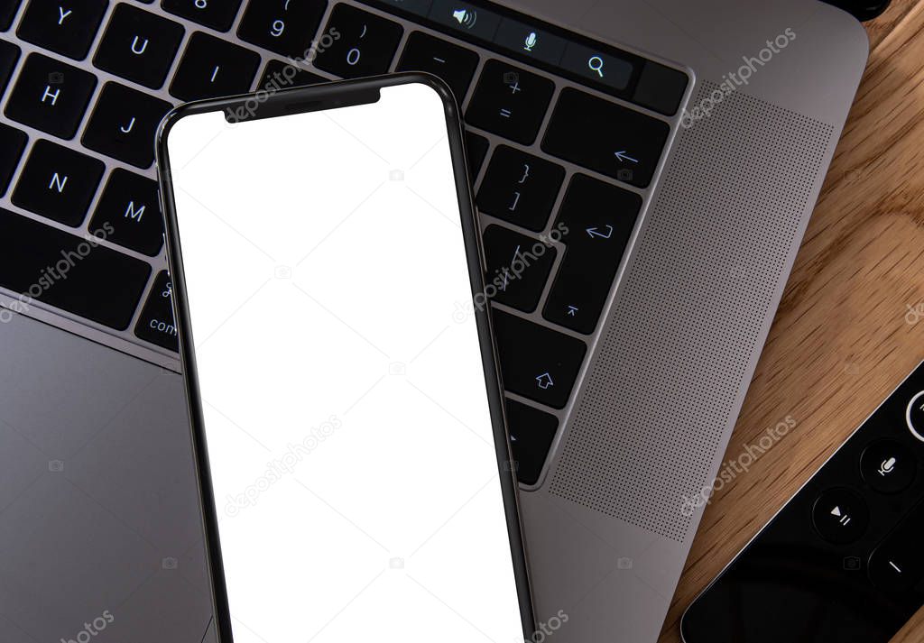 Smartphone with blank frameless screen on laptop keyboard