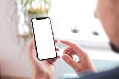 Büyük boş ekran ve modern çerçeve ile siyah smartphone daha az tasarım ev iç, oturma odasında beyaz arka plan açılı konumuna izole - tutan adam el
