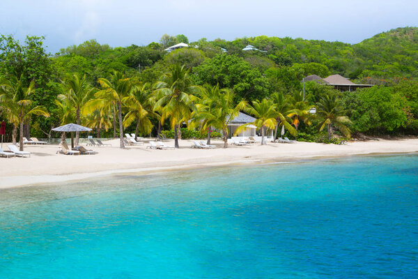 Antigua, Caribbean islands - May 20, 2019: English Harbour view at Galeon beach (Free man bay) with sandy beach, sun beds and umbrellas