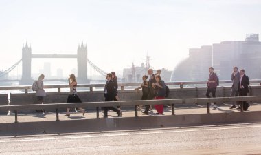 Londra, Ingiltere-19 Nisan 2018: ofis çalışanları, Avrupa 'nın önde gelen iş ve finans alanı olan Londra şehrine giden yolda sabah erkenden Londra Köprüsü 'nü geçiyor. Acele saatleri