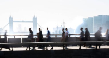 Londra, Ingiltere-19 Nisan 2018: ofis çalışanları, Avrupa 'nın önde gelen iş ve finans alanı olan Londra şehrine giden yolda sabah erkenden Londra Köprüsü 'nü geçiyor. Acele saatleri