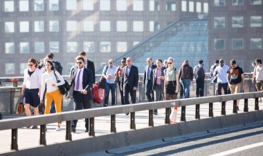 Londra, Ingiltere-19 Nisan 2018: ofis çalışanları, Avrupa 'nın önde gelen iş ve finans alanı olan Londra şehrine giden yolda sabah erkenden Londra Köprüsü 'nü geçiyor. Acele saatleri