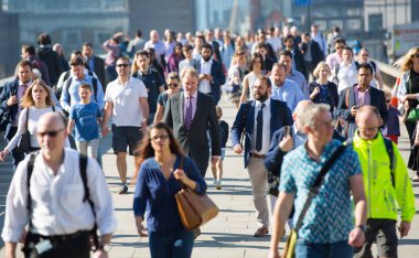 Londra, Ingiltere-19 Nisan 2018: ofis çalışanları, Avrupa 'nın önde gelen iş ve finans alanı olan Londra şehrine giden yolda sabah erkenden Londra Köprüsü 'nü geçiyor. Acele saatleri