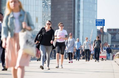 Londra, Ingiltere-19 Nisan 2018: ofis çalışanları, Avrupa 'nın önde gelen iş ve finans alanı olan Londra şehrine giden yolda sabah erkenden Londra Köprüsü 'nü geçiyor. Acele saatleri