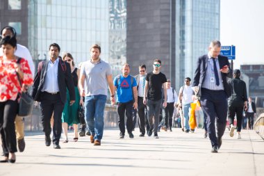 Londra, Ingiltere-19 Nisan 2018: ofis çalışanları, Avrupa 'nın önde gelen iş ve finans alanı olan Londra şehrine giden yolda sabah erkenden Londra Köprüsü 'nü geçiyor. Acele saatleri