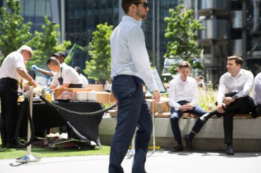 Londra, İngiltere - 26 Haziran 2018: Güneş ışığına karşı şehirde yürüyen bir grup iş adamı. Güzel güneş tarafından sokak aydınlatılmış, City of London modern meşgul kavramı.