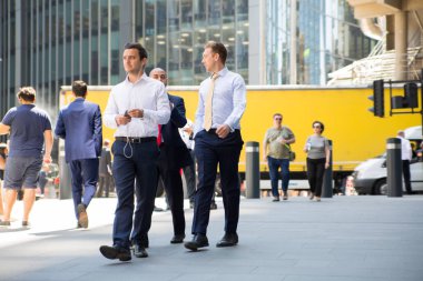 Londra, İngiltere - 26 Haziran 2018: Öğle yemeği saatinde Londra'daki Lloyds binasının yanında yürüyen iş adamları ve ofis çalışanları