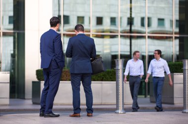 Londra, İngiltere - 8 Mayıs 2019: Canary Wharf meydanında yürüyen iş adamları, iş ve finans aryası. Modern yaşam kavramı