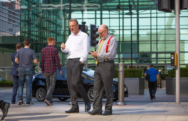 Londra, İngiltere - 8 Mayıs 2019: Canary Wharf meydanında yürüyen iş adamları, iş ve finans aryası. Modern yaşam kavramı