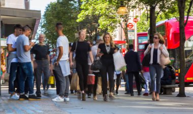 Londra, İngiltere - 9 Haziran 2019: Oxford caddesinde yürüyen insanların bulanık görüntü grubu, ana cadde ve butik alışverişiçin ana hedef. Nakliye çantalarını önemseyen insanlar.